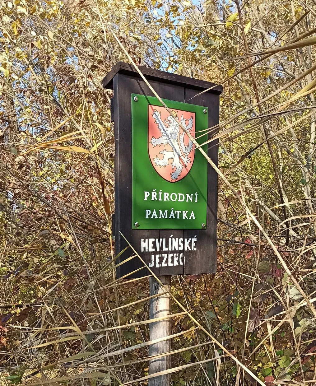 An overgrown information board at Hevlínské jezero.